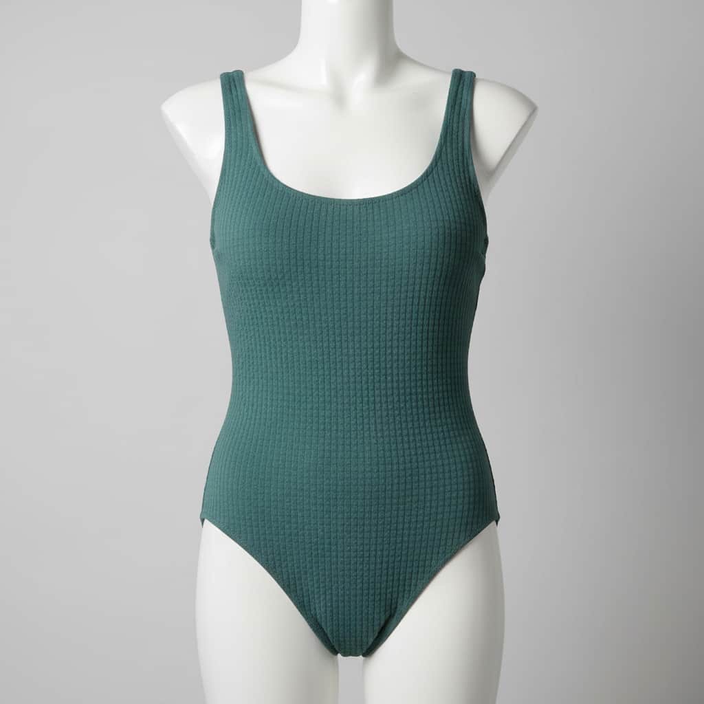 Maillot de bain une pièce minimaliste en tissu gaufré, présenté sur un mannequin dans un studio épuré